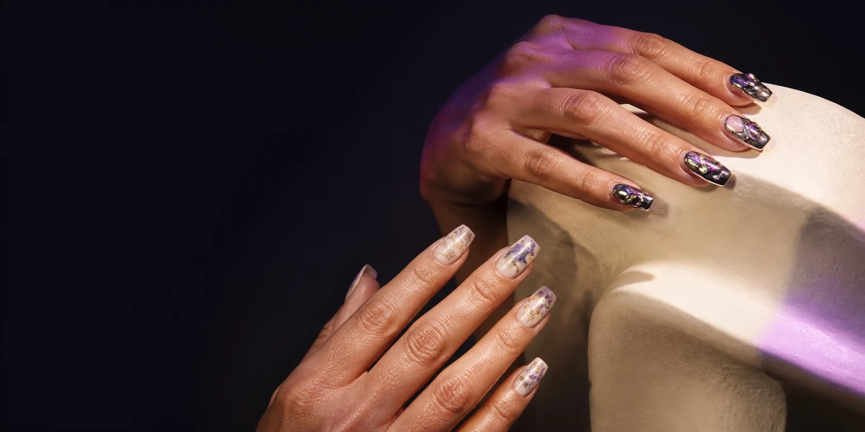 Two hands wearing distinctive press-on nail art